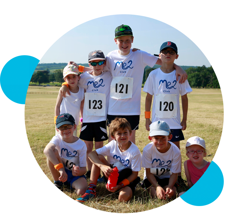 A group of children wearing running t-shirts with the Me2 Club logo on
