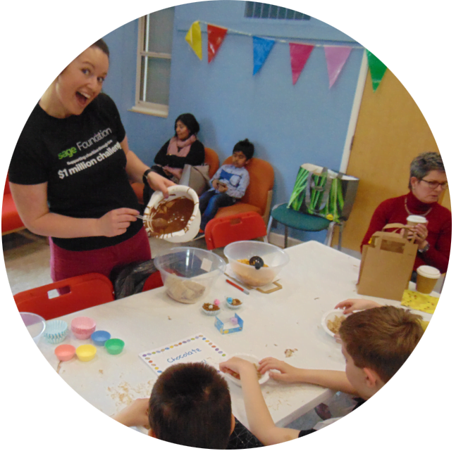 A member of staff helping children with a baking activity