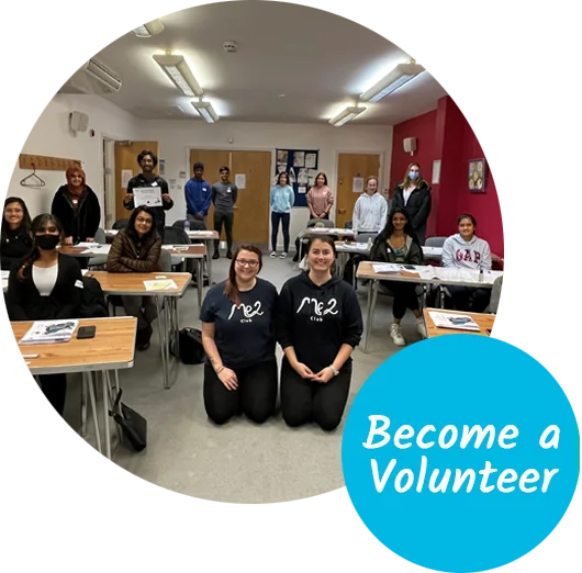 A group of volunteers and Me2 Club staff sitting at tables at a volunteer training course. The text reads "Become a volunteer"