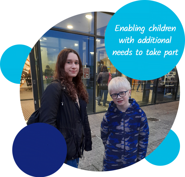 A volunteer and child standing outside a leisure centre. The text reads "Enabling children with additional needs to take part"